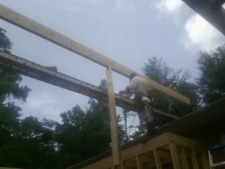 Carpenter setting a ridge beam over a new addition frame — Ice Dam Removal by Roofing Brothers in Buffalo Prairie