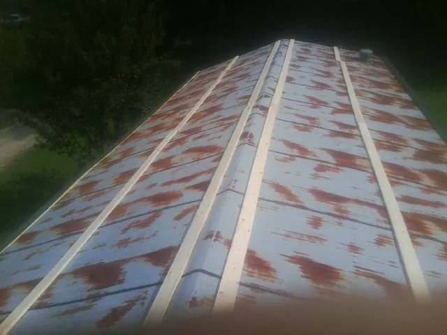 Rusted metal roof panels with new wood purlins before replacement — Storm Damage Roof Repair in Buffalo Prairie by Roofing Brothers