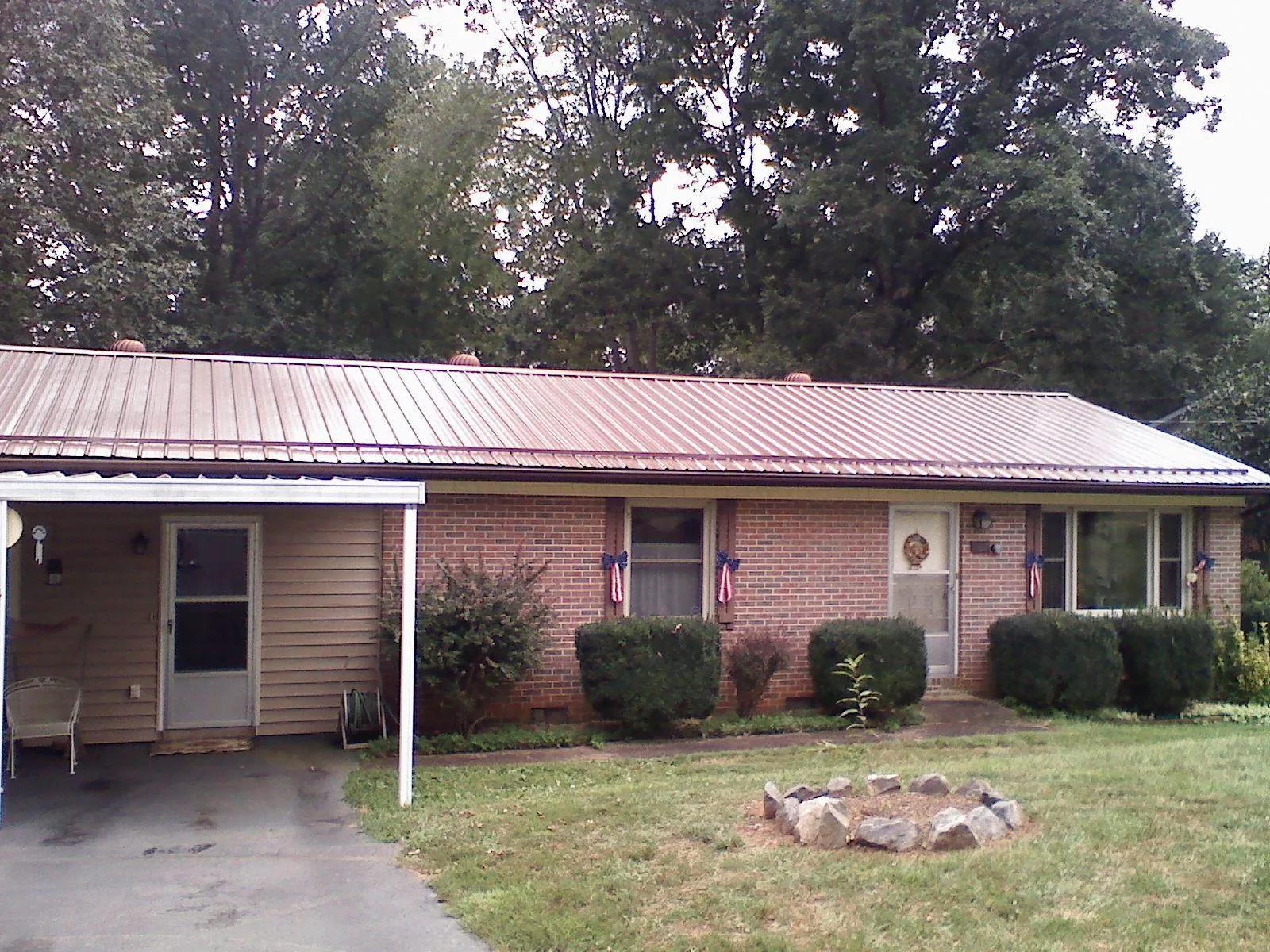 Bronze metal roof and carport on a brick ranch home — Roof Repair work by our crew in Buffalo Prairie